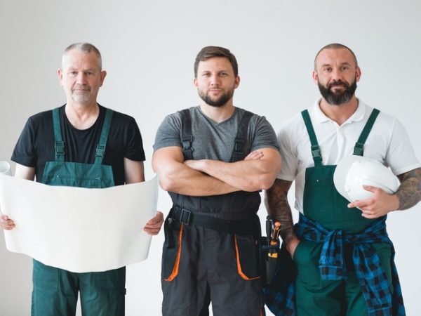 Group of three builders preparing for remodeling of the apartment
